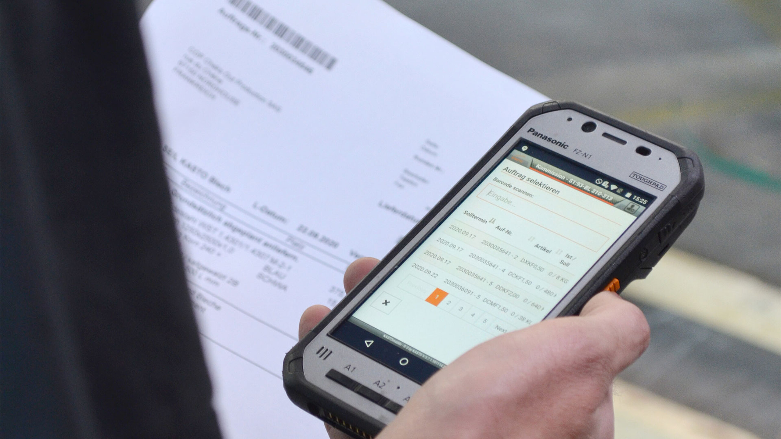 Mitarbeiter nutzt Smartphone zur Bestandskontrolle im Metalllager