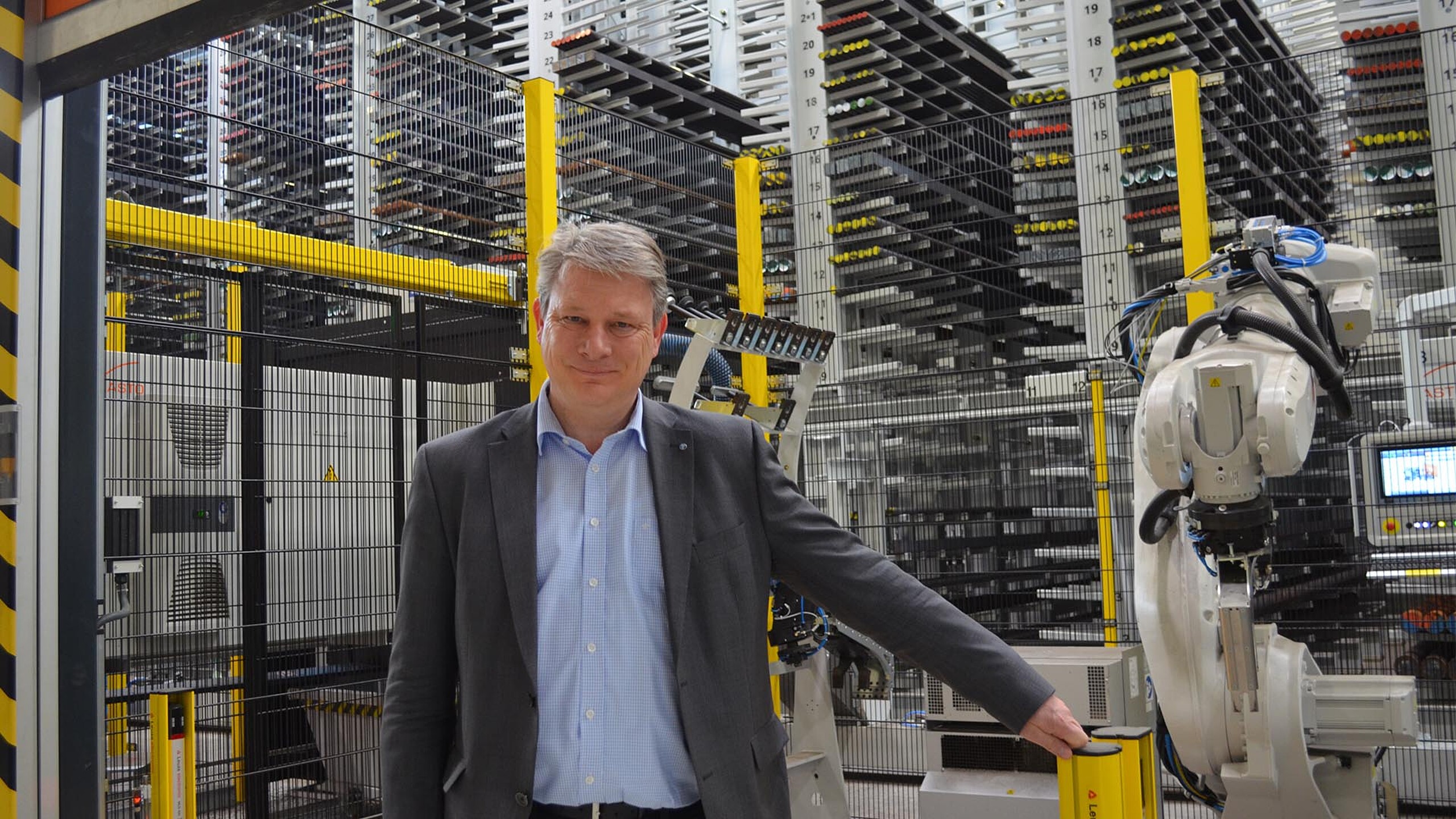 Referenzkunde vor automatisierter KASTO Roboterzelle im Langgutlager