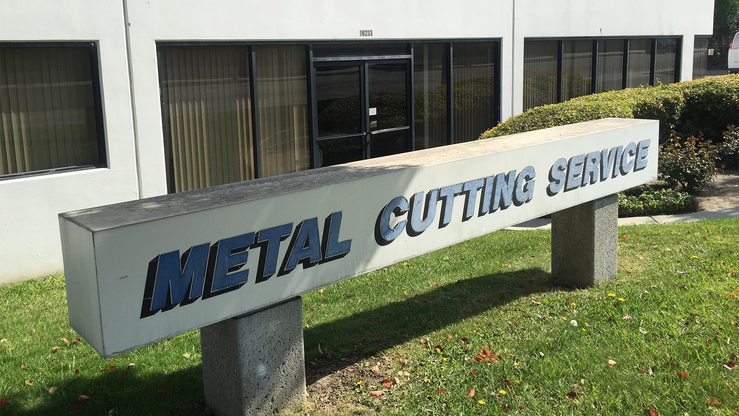 Enseigne « Metal Cutting Service » devant un site de production