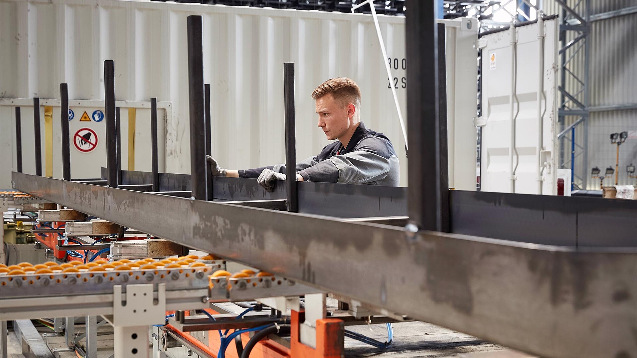 Employé contrôlant le flux de matériaux dans la transformation automatisée des métaux