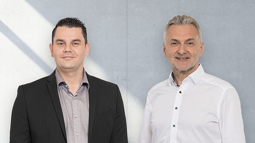 Ansprechpartner im Vertrieb von KASTO vor einem automatisierten Lagersystem