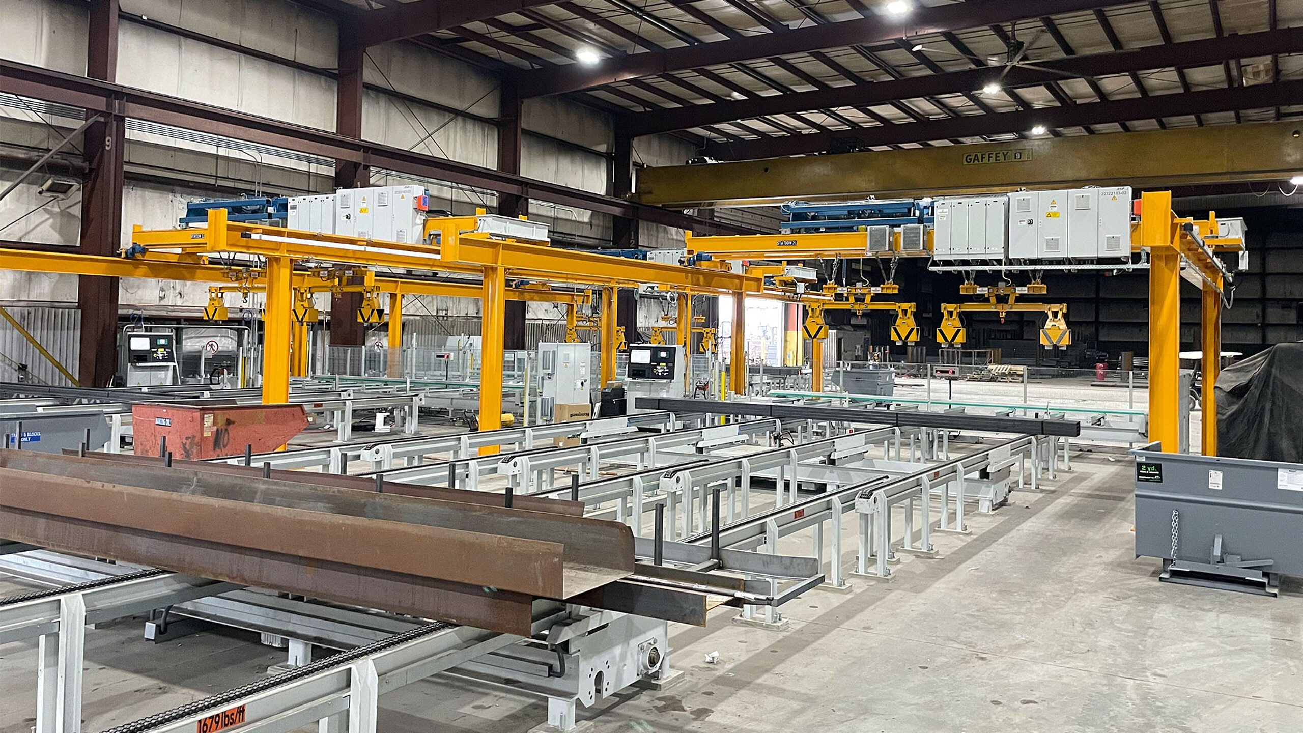 Magasin automatique pour produits longs avec pont roulant et convoyage intégré